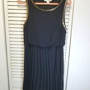Black pleated dress, longer in the back.  Metal trim